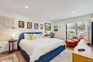 a bedroom with a blue bed and a living room at Heron Escape in Bodega Bay