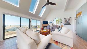 a living room with white furniture and large windows at Heron Escape in Bodega Bay