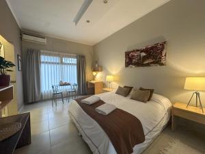 a bedroom with a large bed and a table at Los Plátanos cabañas & suites in Moreno +126 photos