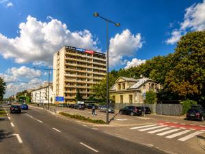 a building on the side of a street with cars at JACUZZI & SAUNA Apartament Warszawa Wola in Warsaw