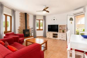 a living room with red furniture and a flat screen tv at Villa Maria Large Private Pool AC WiFi in Cala en Porter