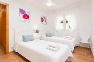 two white beds in a room with a window at Villa Maria Large Private Pool AC WiFi in Cala en Porter +5 photos