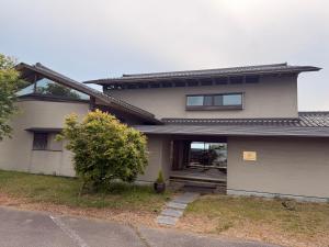 a house with a tree in front of it at the Mikuni Residence in Sakai