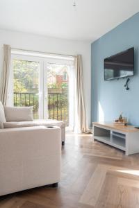a living room with a white couch and a large window at 2 BR Apartment- Private Parking in Newport