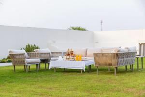 a patio with a couch and a table and chairs at Groves Chalet in Rumays