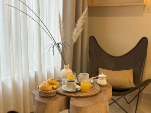 a table with a breakfast of coffee and orange juice at Los Plátanos cabañas & suites in Moreno
