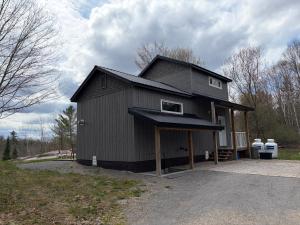 a large black house with a gambrel roof at Hidden Getaway in Pembroke