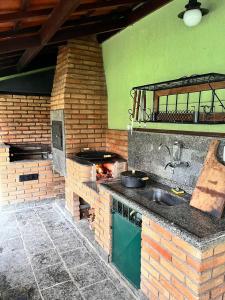 an outdoor kitchen with a stove and a sink at Casa da Jabuticaba! in Itatiaia