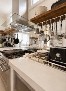 a kitchen with a stove and some pots and pans at Avalon Beach Cottage- The Islander in Avalon