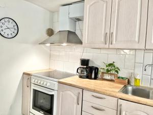a kitchen with white cabinets and a clock on the wall at Joselia in Falkenberg +14 photos