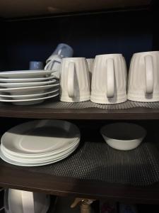 a shelf filled with white plates and bowls at Guest House "Ro"kumano in Shimonoseki +54 photos