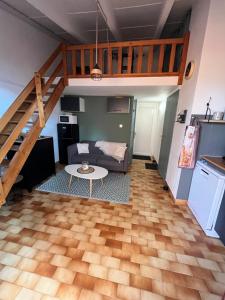 a living room with a loft with a couch and a table at Vacances Cap d'Agde 1 chambre, 1 mezzanine, parking et piscine in Cap d'Agde