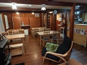 a restaurant with wooden floors and tables and chairs at Yamagata Zao Pension Apron Stage in Kaminoyama