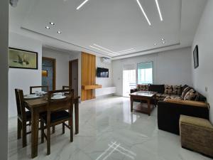a living room with a table and a couch at Résidence EL AMAL in Martil