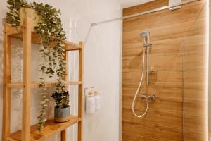 a bathroom with a shower with a wooden wall at Aria Apartments in Prievidza +10 photos