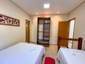 a small room with two beds and a closet at Casa Amoreira Paraty in Paraty