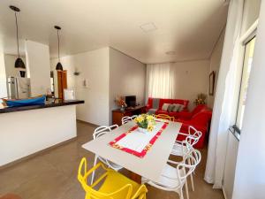 a kitchen and a living room with a table and chairs at Casa Amoreira Paraty in Paraty