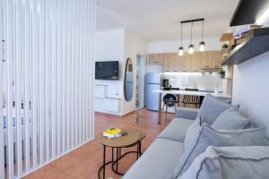 a living room and kitchen with a couch and a table at Skyview Suites in Lefkada