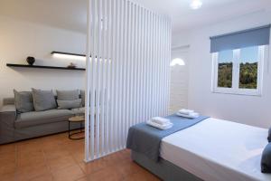 a white bedroom with a bed and a couch at Skyview Suites in Lefkada +51 photos