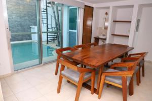 a dining room with a wooden table and chairs at Casa con alberca en el centro de Puerto Progreso in Progreso