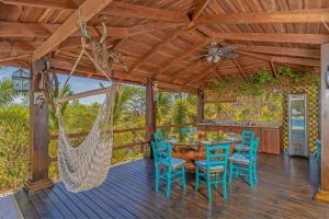 a porch with a hammock and a table and chairs at Villas Roma Del Mar in Naranjo