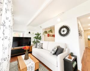 a living room with a white couch and a tv at Las casitas de Zamorano in La Esperanza