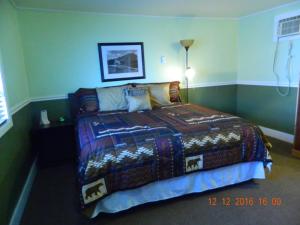 a bedroom with a bed with a colorful blanket at Country Motor Inn in Livingston