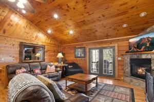 a living room with a fireplace in a log cabin at Eagles View in Boone