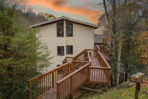 a house with a wooden deck in the woods at Heavens Door in Beech Mountain