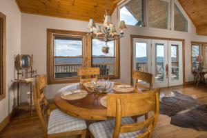 a dining room with a table and chairs and windows at Serenity in Blowing Rock