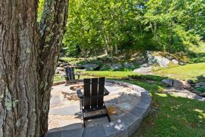two benches sitting next to a tree in a park at Eagle Ridge Creek in Banner Elk