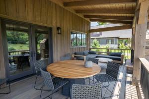 a patio with a wooden table and chairs on a deck at Sweetgrass Getaway in Blowing Rock