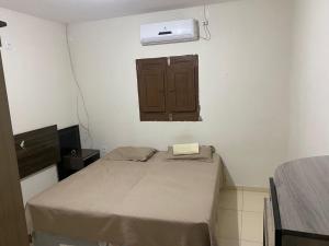 a small bedroom with a bed and a air conditioner at Casaavatar12 in Piranhas