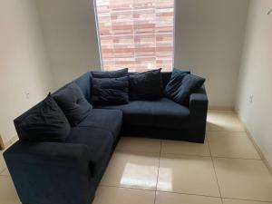 a black couch in a living room with a window at Casaavatar12 in Piranhas