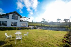 a table and chairs in the yard of a house at The Tea Garden in Nuwara Eliya