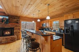 a kitchen with a black refrigerator and a fireplace at Little Elk Lodge in Elk Park