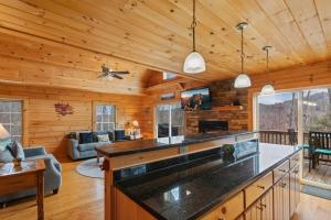a log cabin kitchen and living room with a fireplace at Little Elk Lodge in Elk Park