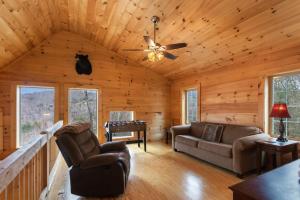 a living room in a log cabin with a ceiling fan at Little Elk Lodge in Elk Park +13 photos