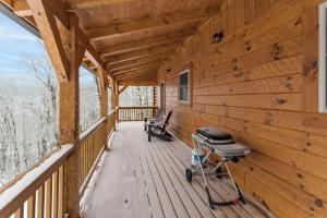 a wooden cabin with a grill on the deck at Cozy Rustic Cabin in Sugar Mountain