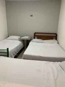 a room with two beds and a table in it at Acacias home in Acacías