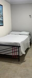 a large bed in a room with a white wall at Acacias home in Acacías