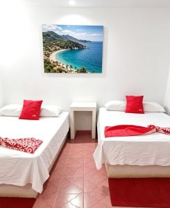 two beds in a room with a view of the ocean at Hotel Zihua Malibu in Zihuatanejo