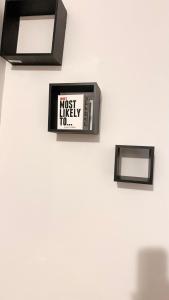 eine Uhr an einer weißen Wand mit einem höchstwahrscheinlichen Zeichen in der Unterkunft Charming space in Lynn