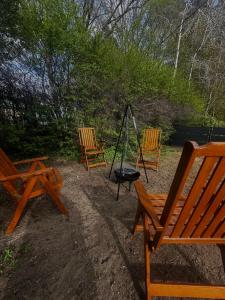 a group of three wooden chairs and a swing at Apartament Bydlino in Bydlino