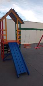 a playground with a slide and swings at Recanto Rafaela 2 in Olímpia