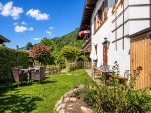 a garden with a table and chairs next to a house at Ferienwohnung Feichten in Westendorf