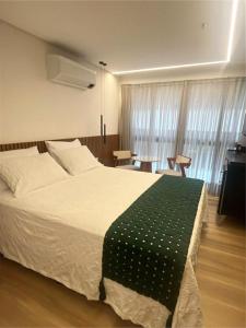 a bedroom with a large bed with a green blanket at Cabo Branco Flat Amsterdam in João Pessoa +23 photos
