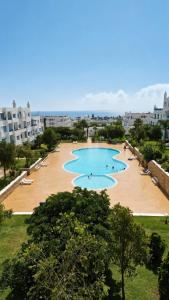 a large pool with people swimming in it at Spacious Apartment with views to sea and pool Kabila vista Families only in Marina Smir