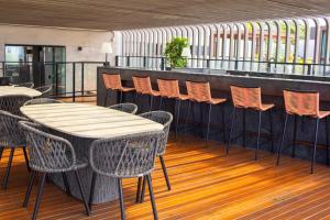 a row of chairs and tables on a balcony at Cabo Branco Flat Amsterdam in João Pessoa