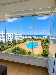 a room with a large window with a view of the ocean at Spacious Apartment with views to sea and pool Kabila vista Families only in Marina Smir
